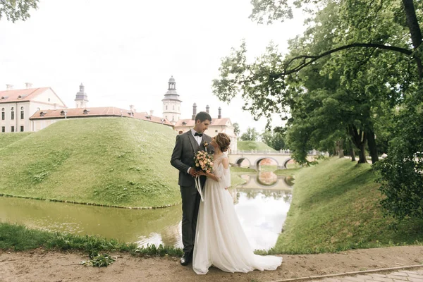 Avrupa 'da eski bir şatonun arka planında birbirine aşık güzel, zarif bir çift.