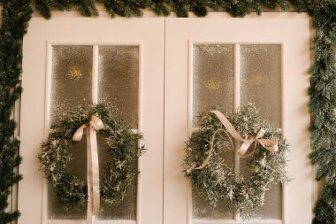 Noel ve yeni yılın dekoru. Çelenklerle süslenmiş güzel bir cephe, seçici bir odak noktası.