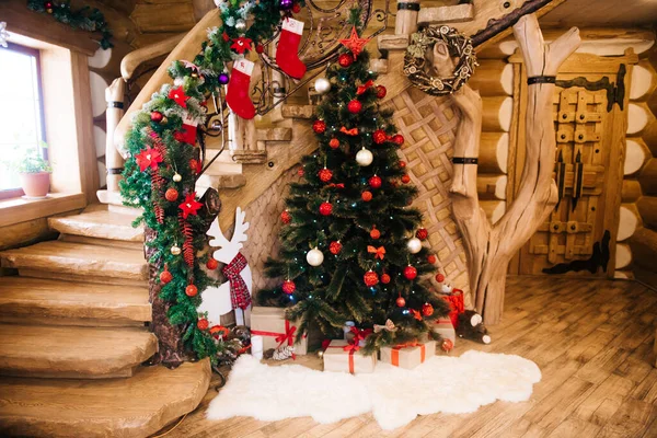 Noel süsleri: Ahşap bir merdivenin arka planında kırmızı oyuncaklar olan Noel ağacı. Noel Fotoğraf Bölgesi. Noel ağacı olan bir Noel fotoğrafı bölgesi.