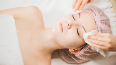 Güzellik uzmanı bir kızın cilt durumunu iyileştirmek için bir prosedür uygular.
