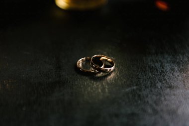 Siyah bir zemin üzerinde gelin ve damat için zarif alyanslar, röfle, makro, seçici odaklı