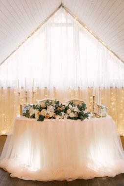 Restoranda düğün dekoru. Çiçeklerle süslenmiş güzel parlak podyum.