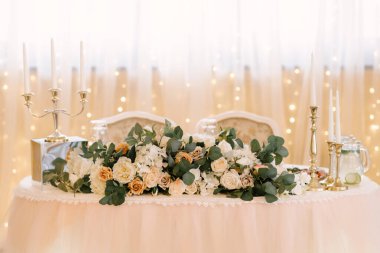 Restoranda düğün dekoru. Çiçeklerle süslenmiş güzel parlak podyum.