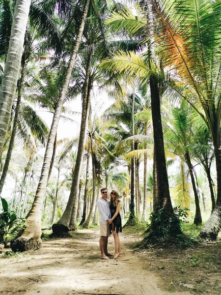自然を背景に女の子と魅力的な男の肖像画 ヤシの木の近くにポーズをとる旅人の写真 — ストック写真