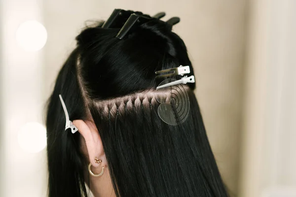 미용실에서 미용실에 소녀에게 미용사는 머리를 뻗는다 캡슐을 머리카락 조각들을 덮는다 — 스톡 사진