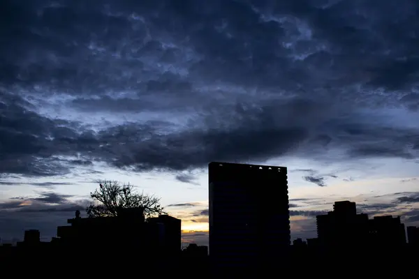 夜明けに撮影した写真 建物と暗く青い空のコントラストが高い — ストック写真