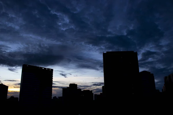 夜明けに撮影した写真 建物と暗く青い空のコントラストが高い — ストック写真