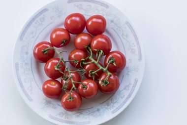 Bazı küçük şirin domates bir tabak içinde yüksek-açı çekim taşlama. T