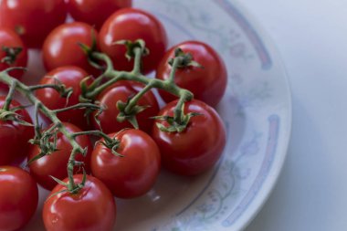 Bazı küçük şirin domates bir tabak içinde yüksek-açı çekim taşlama. C