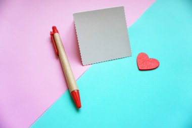 Sevgililer Günü geçmişi. Boş boş defter, parlak bir arkaplan üzerinde kalem ve kalp, üst görünüm. Metin için boş alan