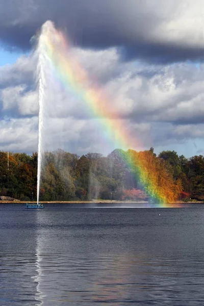 Alster Fountain, water fountain creating a rainbow on the Inner Alster Lake in the center of Hamburg, Germany, Europe