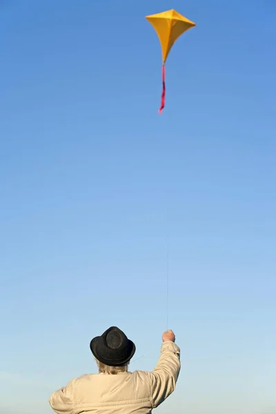 Elderly Man Flying Kite Stock Photo