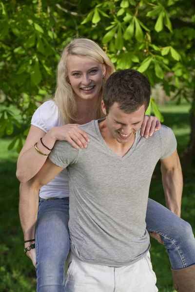 Jeune Homme Portant Une Jeune Femme Par Piggyback Dans Parc — Photo