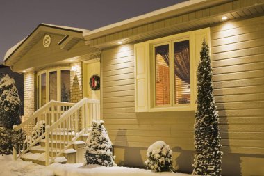 residential home illuminated in winter with Christmas decorations clipart