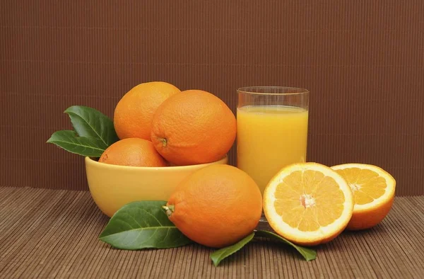 Pohár Narancslé Mellett Egy Tálba Narancs — Stock Fotó