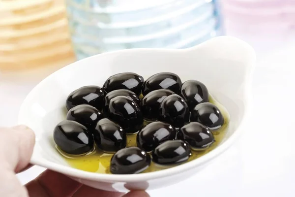 Mano Sosteniendo Aceitunas Negras Pequeños Cuencos Porcelana — Foto de Stock