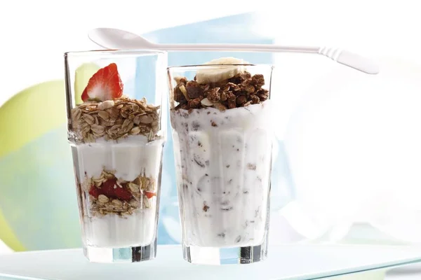 Muesli and chocolate muesli with yogurt and in a small glass jar, sliced banana, strawberries