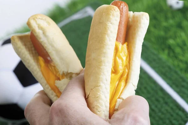 Hand Holding Two Hot Dogs Football Pitch — Stock Photo, Image