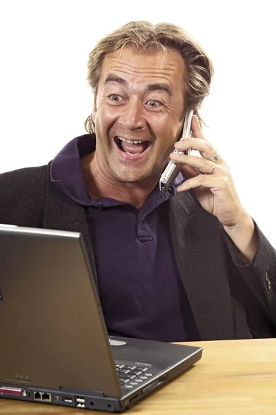 Cep Telefonuyla Konuşan Bir Adam Dizüstü Bilgisayarın Önünde Oturuyor — Stok fotoğraf