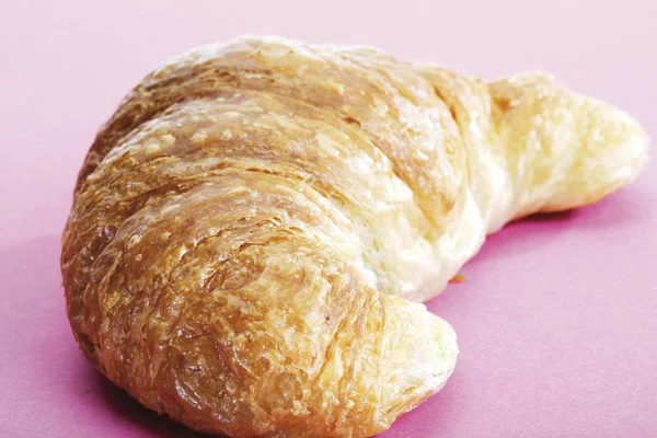 Croissant Auf Rosa Oberfläche — Stockfoto