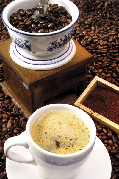 Coffee mill with coffee beans and coffee cup