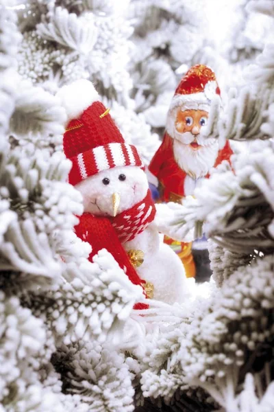 Snowman figure and chocolate Santa Claus — Stock Photo, Image