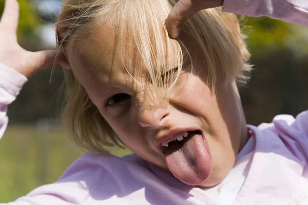 Yaşında Bir Kız Dilini Çıkarıp Yüzünü Buruşturuyor — Stok fotoğraf
