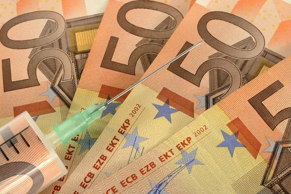 ユーロ紙幣と注射針 現金注入の象徴的な絵 — ストック写真