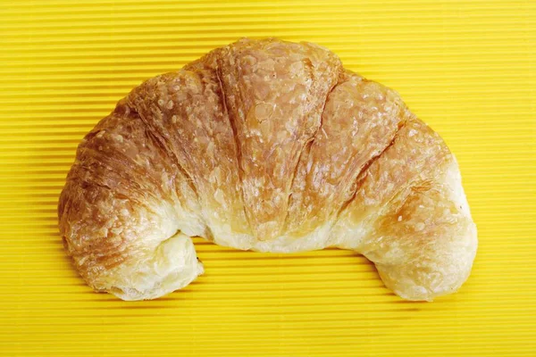 Croissant Auf Gelber Oberfläche — Stockfoto