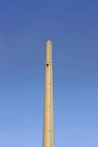 Industrial smoke stack over blue sky