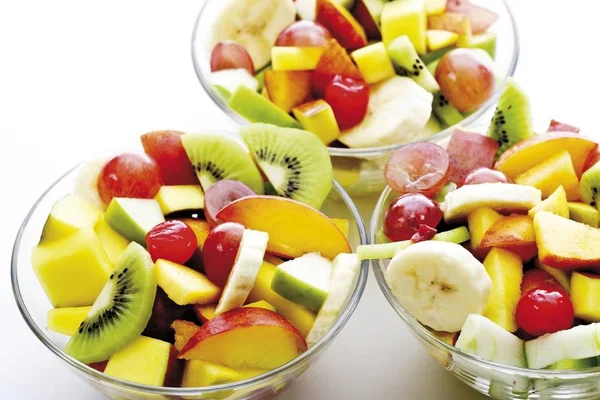 Fruit salad: kiwis, bananas, apples, peaches, mangoes, grapes and maraschino cherries