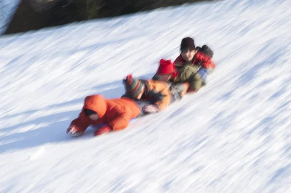 Chain Children Sliding Bellies Downhill — Stock Photo, Image