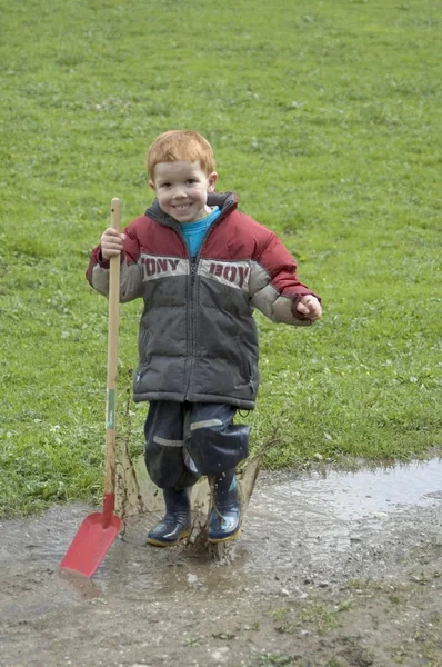 Pojken Leker Och Har Kul Regnig Dag Med Spade Leran — Stockfoto