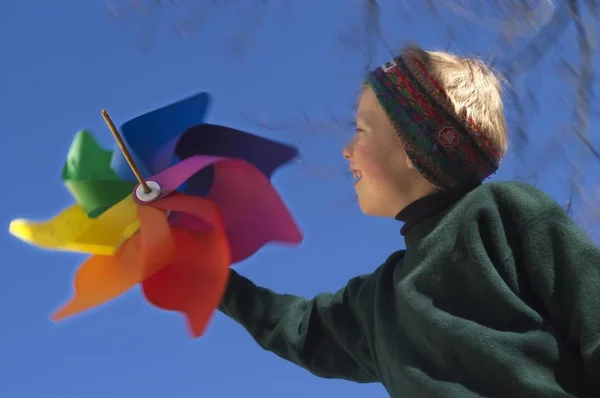Renkli Rüzgâr Tekerleği Olan Sekiz Yaşında Bir Çocuk — Stok fotoğraf