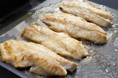 Redfish fillets being fried clipart
