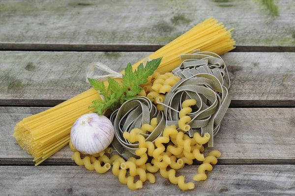 stock image Various types of pasta on a wooden board