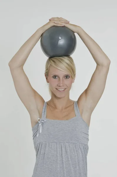 Egzersiz Topu Iki Eliyle Başını Tutan Genç Kadın — Stok fotoğraf