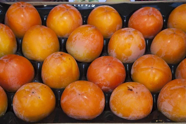 Persimmons (Diospyros kaki) in a fruit crate, Germany, Europe