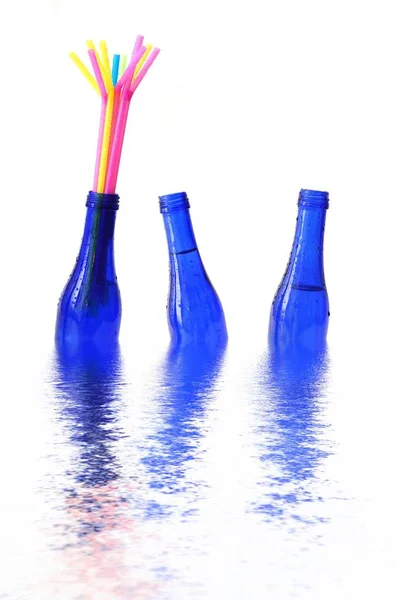 Blaue Flaschen Die Wasser Schwimmen Eine Mit Farbigen Strohhalmen — Stockfoto