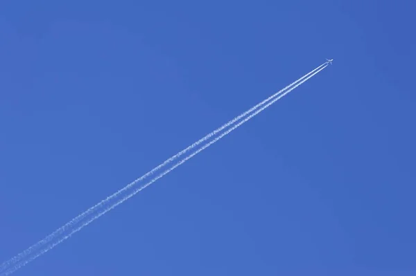 Vliegtuig Met Contrails Tegen Een Blauwe Lucht — Stockfoto