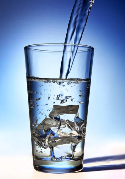 Water Gegoten Een Glas Met Ijsblokjes — Stockfoto