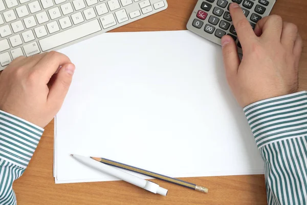 Adam ahşap masa hesap makinesi ile çalışmaya eller