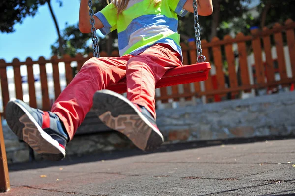 Kid feet on swing at playground on summer — Stock Photo, Image