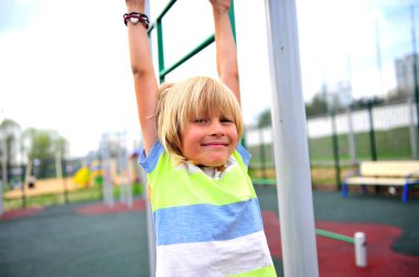 Sevimli küçük çocuk çocuklar Bahçesi üzerinde asılı