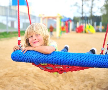 Küçük çocuk salıncakta gülümseyen