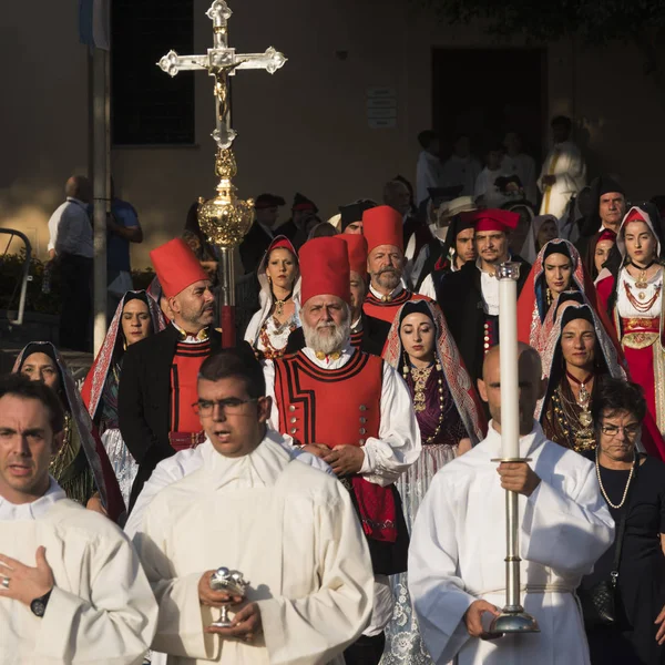 2019年9月29日 意大利 加利福尼亚 卡吉拉里 身着传统服装的撒丁岛人的游行 男人戴着大红帽子和红色外套 女人穿着长披肩和长项链 一个牧师带着一个大十字架 — 图库照片