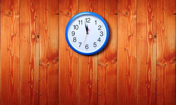 Blue wall clock on a wooden background — 스톡 사진