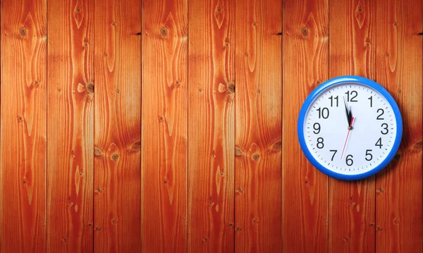 Blue wall clock on a wooden background — Stock Photo, Image
