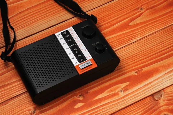 Vintage radio for listening to radio programs on a wooden background