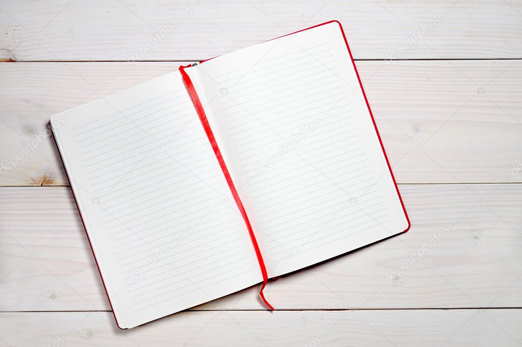 Red notebook for everyday notes on a white wooden background